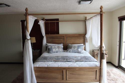 斯瓦科普蒙德Zee Sicht的卧室配有带白色窗帘的天蓬床