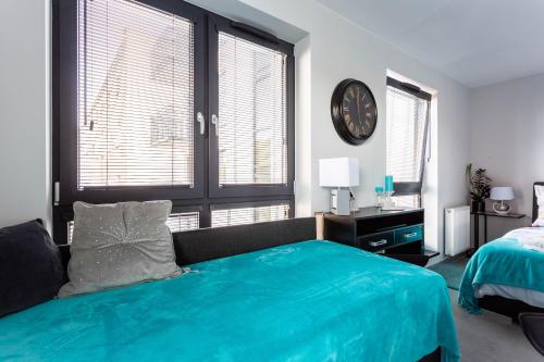 弗罗茨瓦夫Luxury Apartment with Large Terrace的卧室配有一张床,墙上挂着一个钟