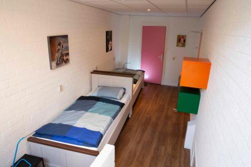 Swalmenut Hen Hoes的一间小卧室,配有一张床和一个粉红色的门