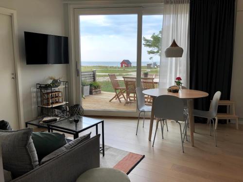 维斯比Superfint boende med havsutsikt, Tofta Strand的客厅配有桌子,享有海景
