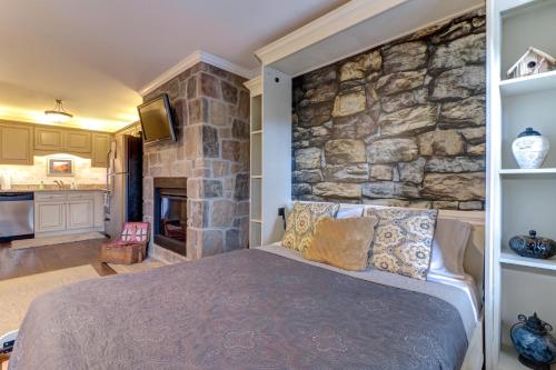 汤森德Little River Loft & Riverfront Gem的一间卧室设有石墙和一张床