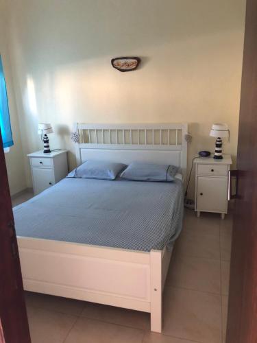 卡帕里卡海岸Vivenda da bela vista的一间卧室配有一张带2个床头柜的大型白色床
