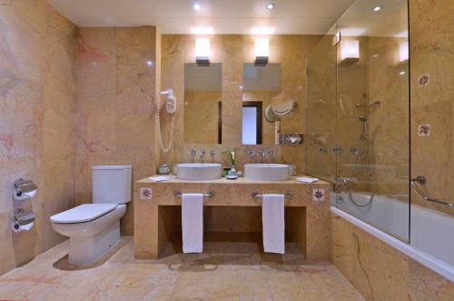 维拉摩拉佩斯塔纳维拉阳光高尔夫度假酒店的浴室配有2个盥洗盆、卫生间和淋浴。