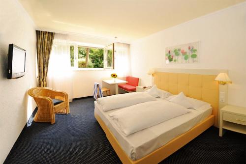 拉纳Kröllnerhof的酒店客房带一张床、一张桌子和椅子
