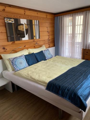 采尔马特Mazot Zermatt的一间卧室设有一张带木墙的大床
