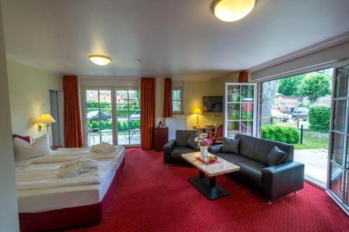 希察克尔希特扎克港酒店 - 易北河的一间卧室配有一张床、一张沙发和一张桌子