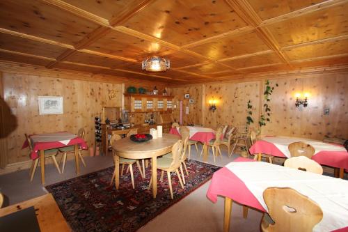 阿罗萨梅扎普那达酒店的餐厅设有桌椅和木墙