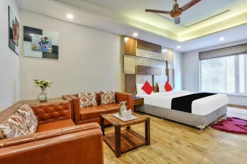 新德里Staybook Hotel Nitya Maharani, New Delhi, Paharganj的酒店客房,配有床和沙发