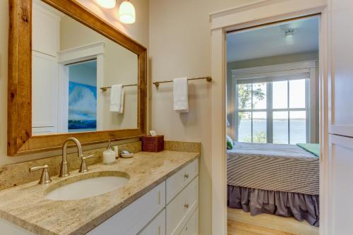伊斯特海湾Orcas Beach Cottage的一间带水槽和镜子的浴室以及一张床
