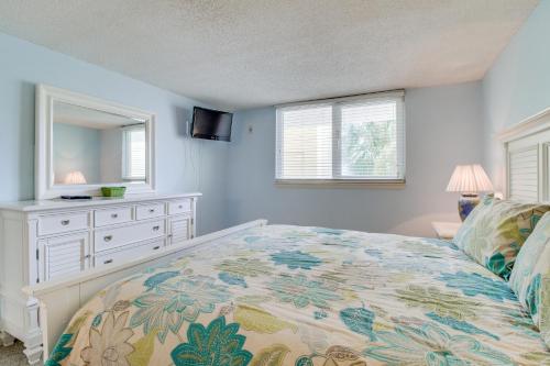 彭萨科拉海滩海外沙丘度假屋的一间卧室配有一张床、梳妆台和镜子
