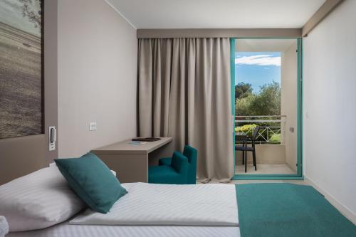 波尔BRETANIDE Sport & Wellness Resort - All Inclusive的一间卧室配有一张床、一张书桌和一个窗户。