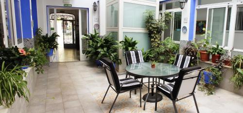 卡夫拉Pensión Guerrero的庭院设有玻璃桌、椅子和植物