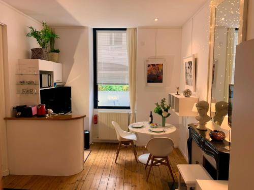 拉罗谢尔L'Art Studio hyper centre的一间带桌子的客厅和一间小厨房