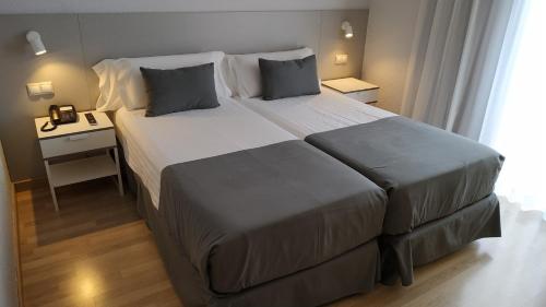 阿利坎特阿利坎特门德斯努涅斯旅馆的酒店客房设有一张大床和一张桌子。