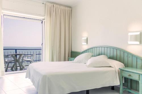 圣卡洛斯拉腊皮塔华尼托普拉塔餐厅酒店的一间带白色床的卧室和一个阳台