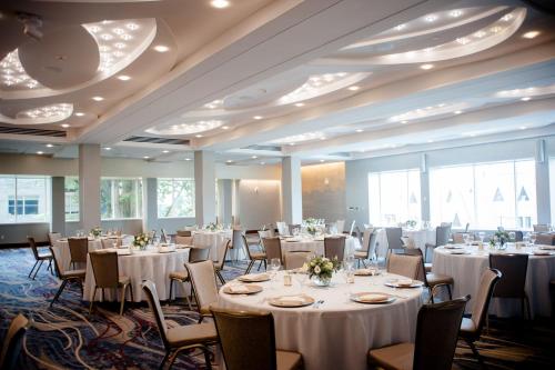 伊萨卡康奈尔大学斯塔特勒酒店 的宴会厅配有白色的桌椅