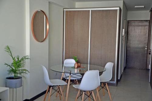 罗萨里奥CDM Temporal的一间设有玻璃桌和白色椅子的用餐室