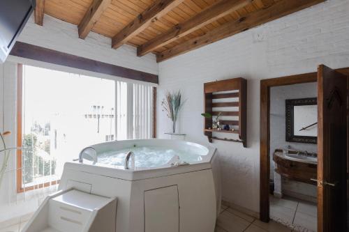 莫雷利亚洛马酒店的白色的浴室设有浴缸和水槽。
