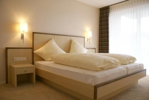 维林根Alm Appartements ehemals Birkenhof的一间卧室配有一张带白色床单的床和一扇窗户。