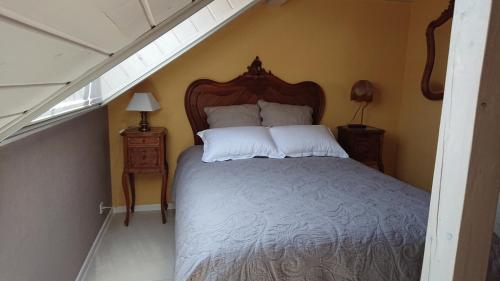 JebsheimGITE DU CLOS PAISIBLE的一间卧室配有一张带木制床头板的床