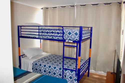 伊基克Departamento Jardines de Huayquique的一张蓝色双层床,位于带床的客房内