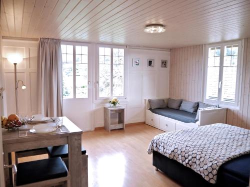 因特拉肯因特拉肯玛丽亚公寓的卧室配有床、桌子和窗户。