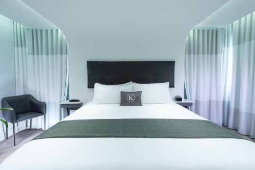迈阿密海滩肯特酒店的卧室配有一张白色大床和一把椅子