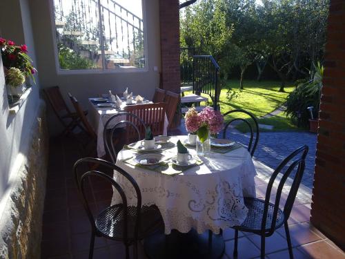 Quintueles罗斯奥贝托斯酒店的庭院里配有一张桌子、白色的桌布和椅子