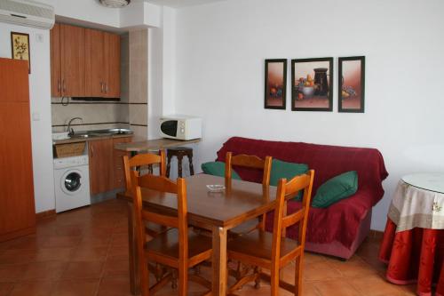 科托里奥斯Apartamentos Mirasierra的厨房以及带桌子和沙发的用餐室。