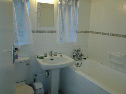 温特顿Ondini Guest House的浴室配有盥洗盆、卫生间和浴缸。