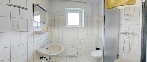 Gorlebenhotel das deichhaus的白色的浴室设有水槽和卫生间。