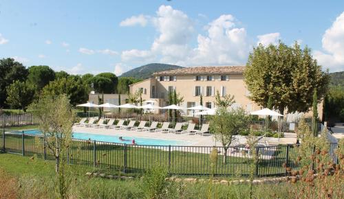 格里莫Clos des Oliviers Grimaud - Meublé de Tourisme的一个带游泳池和椅子的度假胜地和一座建筑