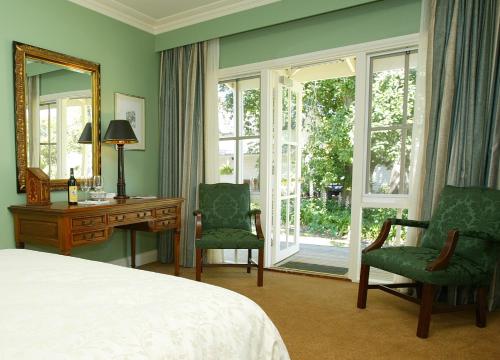卡尔斯Glen Isla House Bed & Breakfast Phillip Island的卧室配有一张床、一张桌子和椅子