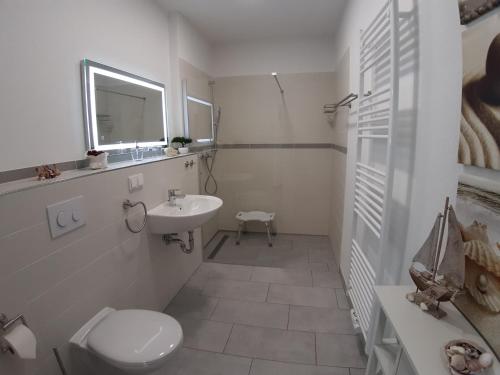 格洛韦Ferienwohnung SteinReich的白色的浴室设有卫生间和水槽。