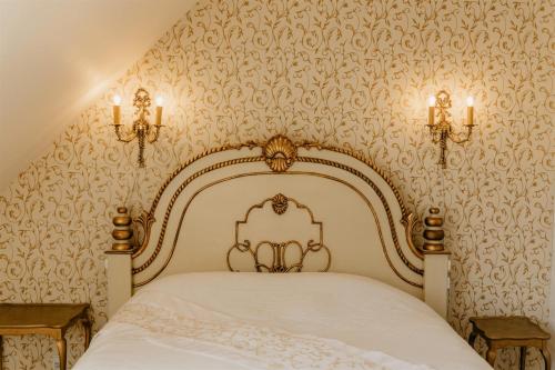 普赖斯特荣主教区长住宿加早餐旅馆的卧室配有白色的壁纸床