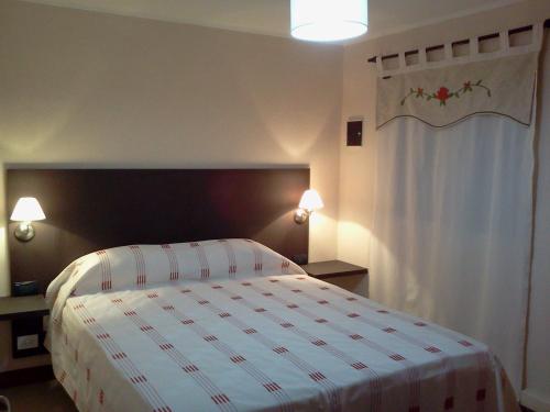 塔菲德尔瓦勒Casa de Montaña Sacha Huasi的一间卧室配有一张带白色和红色毯子的床