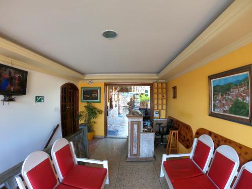 欧鲁普雷图Pousada Marotta的一间设有红色椅子和走廊的等候室