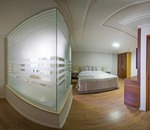 巴西利亚拉古纳广场酒店的一间卧室设有一张床和玻璃墙