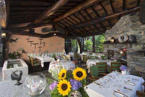Taverne莫托德尔加洛旅馆的一间用餐室,配有白色的桌子和向日葵