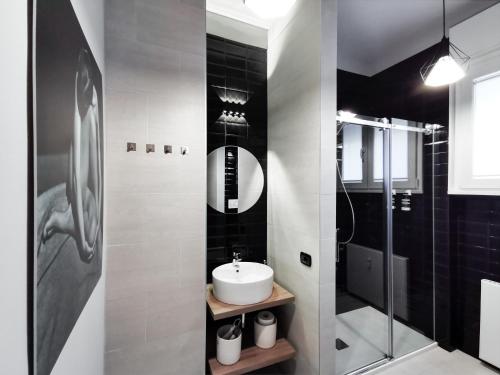 贝加莫F L O R E N T I N Design Apartment ChicLife的一间带水槽和玻璃淋浴的浴室