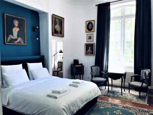 普罗旺斯艾克斯Château de Saint-Girons B&B的一间卧室配有一张蓝色墙壁的床和一扇窗户