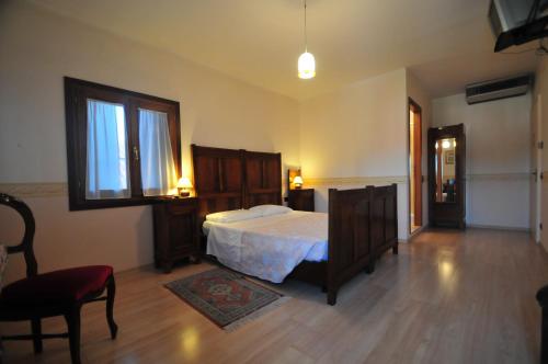 威尼斯洛坎达圣安娜酒店的卧室配有床、椅子和窗户。
