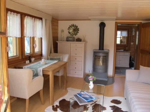 采尔马特Matterhorn Ried Suite的客厅配有桌子和燃木炉。