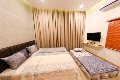 梭桃邑Uzeason Poolvilla Sattahip的一间带两张床和电视的小卧室