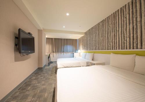 台北久居栈旅店的酒店客房设有两张床和一台平面电视。