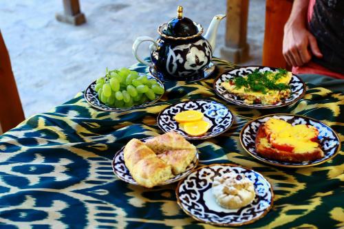 布哈拉Dervish Hostel的餐桌,带盘子和茶壶