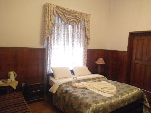 努沃勒埃利耶特列文酒店的一间小卧室,配有一张带窗户的床