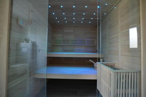 费马恩Ferienhaus Gammendorf Nr. 18的设有带玻璃墙淋浴和浴缸的桑拿浴室