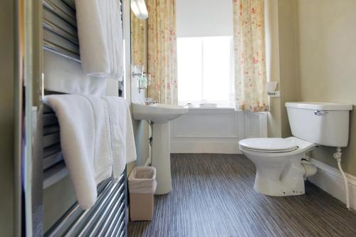瑟索车站酒店的一间带卫生间、水槽和窗户的浴室