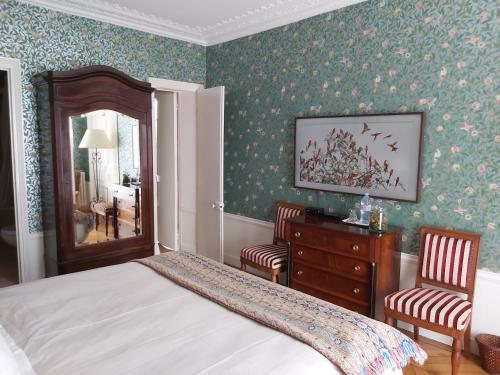 巴黎Le 48 Paris的一间卧室配有一张床、两把椅子和一个梳妆台